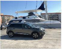Véhicule taxi devant les yachts du port